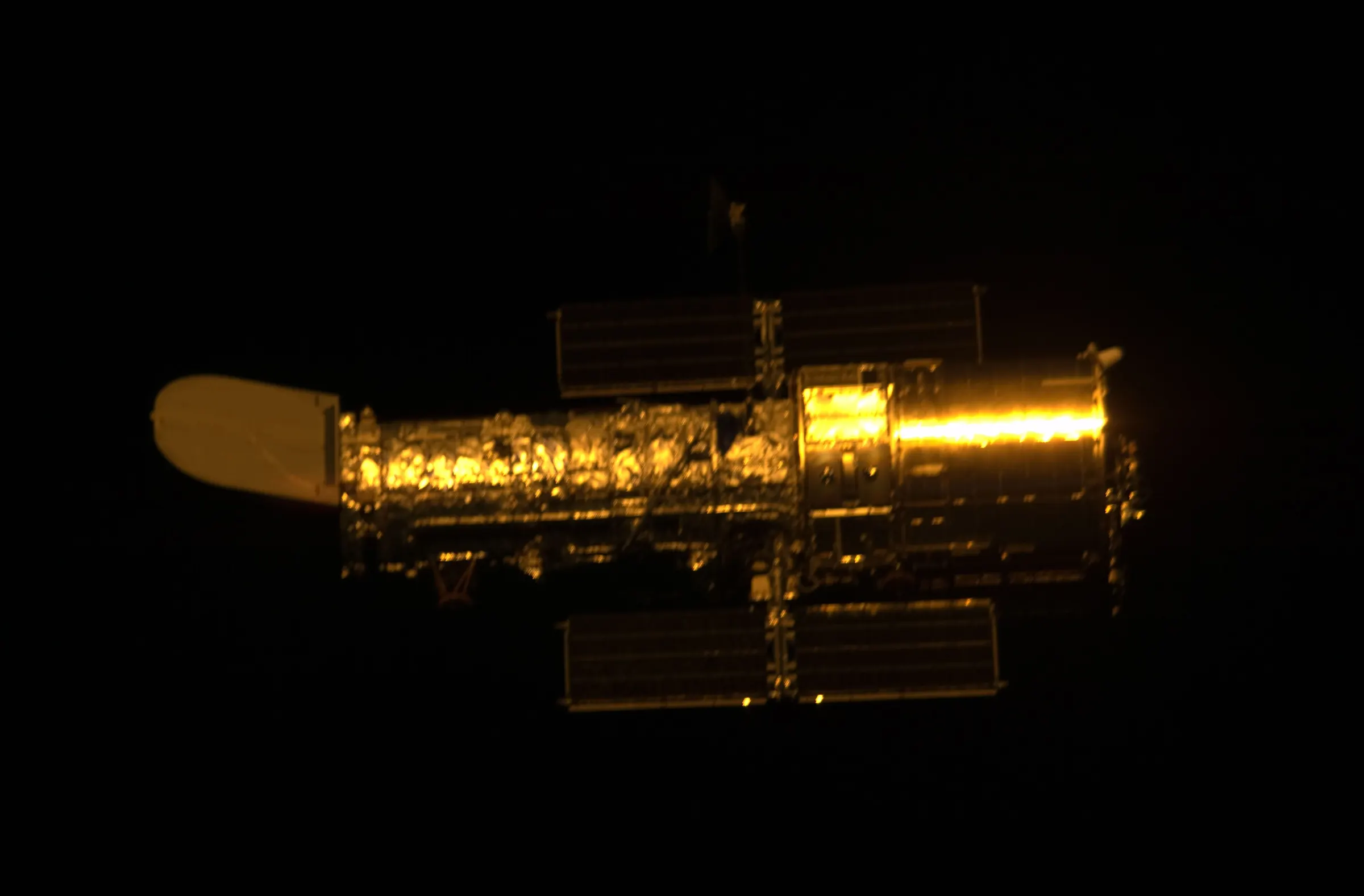 The Hubble Space Telescope drifting in black space after release from Space Shuttle Atlantis.